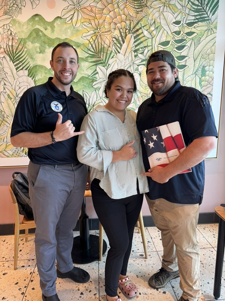 Matt Ball with two clients holding a closing folder on closing day