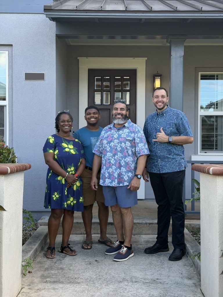 Matt Ball with smiling clients outside the front door of a home on Oahu