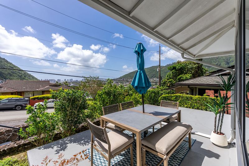 Furnished lanai with an umbrella and green Manoa valley views
