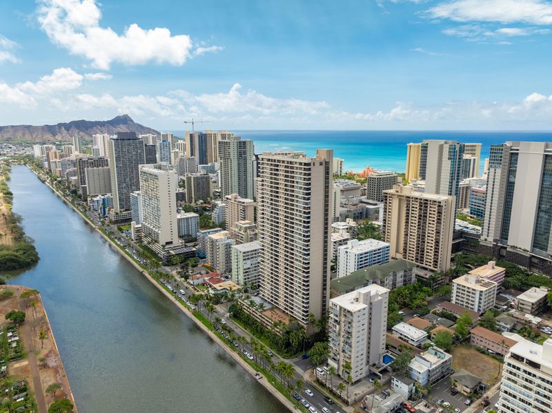 Aerial view of Waikiki high-rises along the Ala Wai Canal with Diamond Head and the ocean beyond